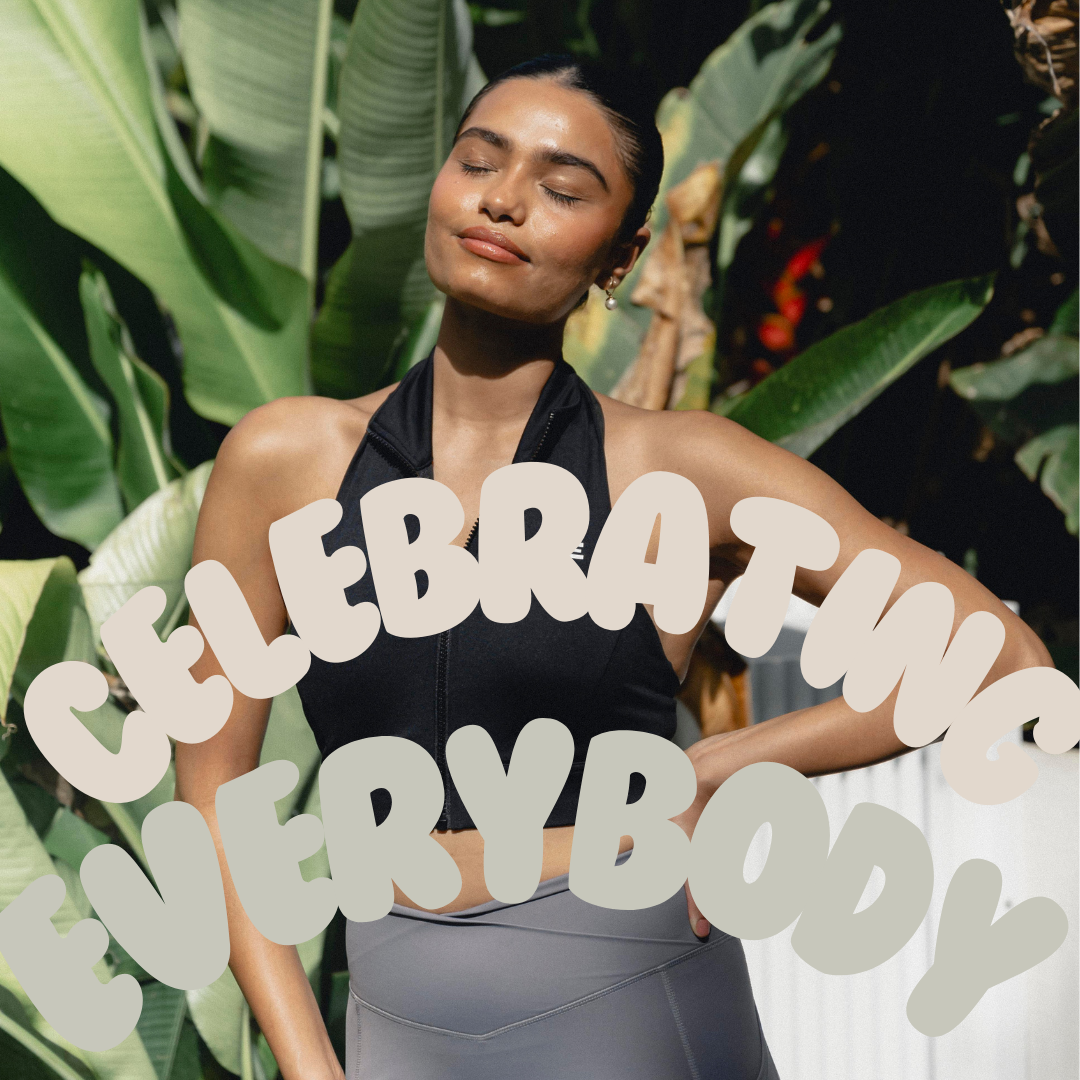 A woman with her eyes closed, standing outdoors, basking in sunlight, wearing a black sports bra and grey leggings. The text "Celebrating Everybody" is written in bold, playful font across the image, promoting body positivity.